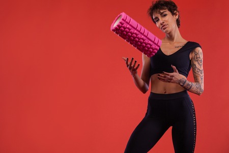 A Strong athletic, female runner on the black background wearing a tight, fitness outfit.