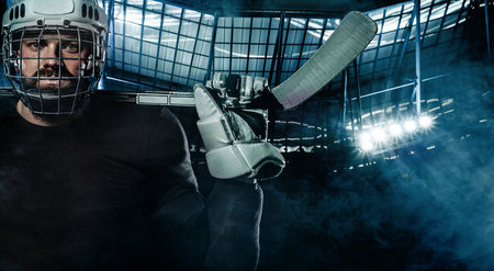 Ice Hockey player in the helmet and gloves on stadium with stick.の写真素材