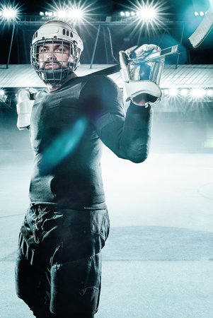 Ice Hockey player athlete in the helmet and gloves on stadium with stick. Action shot. Sport concept.の写真素材