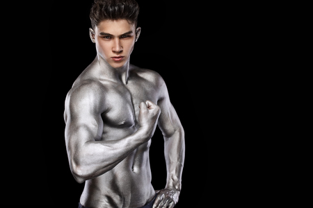 Brutal strong muscular bodybuilder athletic man pumping up muscles on black background. Workout bodybuilding concept. Copy space for sport nutrition ads.の写真素材