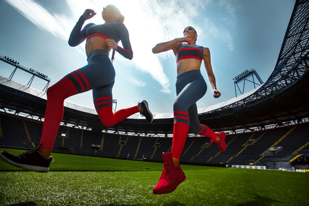 Strong athletic woman sprinter, running on stadium wearing in sportswear. Fitness and sport motivation. Runner concept.の写真素材