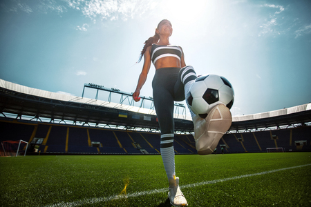 Athletic sporty woman in sportswear with soccer ball on stadium.の写真素材