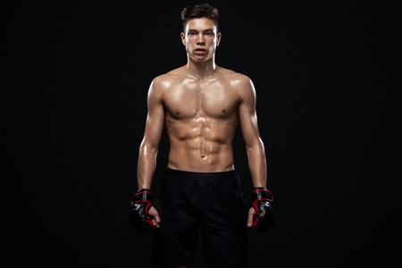 Sportsman teenager boxer fighting on black background with shadow. Copy Space. Boxing sport concept.の写真素材
