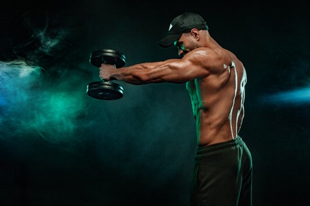 Muscular fitness sports man, atlete with dumbbell in fitness gym.の写真素材