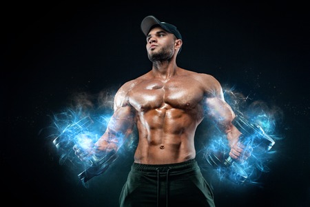 Muscular fitness sports man, atlete with dumbbell in fitness gym. Energy and power.の写真素材