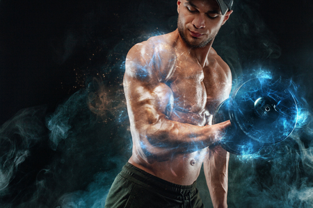 Muscular fitness sports man, atlete with dumbbell in fitness gym. Energy and power.の写真素材