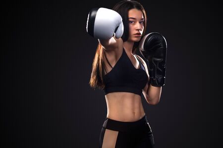 Sportsman, woman boxer fighting in gloves on black background. Boxing and fitness concept.の写真素材