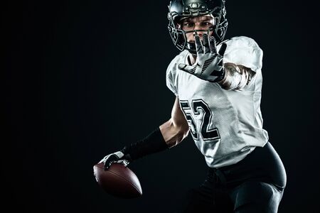 American football sportsman player in helmet isolated on black background. Sport and motivation wallpaper.の写真素材