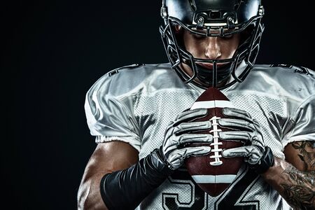 American football sportsman player in helmet isolated run in action on black background. Sport and motivation wallpaper. Team sports,の写真素材