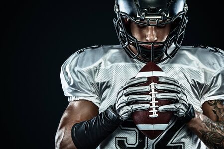 American football sportsman player in helmet isolated run in action on black background. Sport and motivation wallpaper. Team sports,