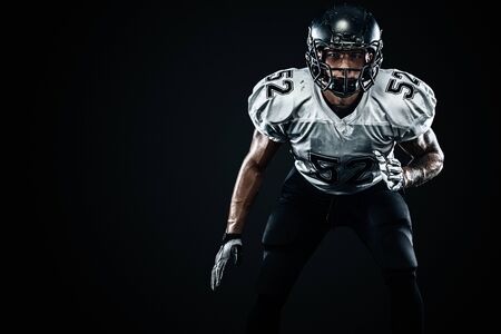 American football sportsman player in helmet on black background. Sport and motivation. Team sports.の写真素材