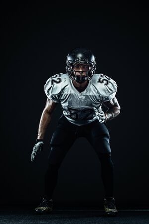 American football sportsman player in helmet on black background. Sport and motivation. Team sports.の写真素材
