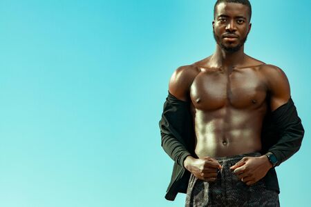 Young sportsmen man, fit athlete are standing on the sky background. Healthy lifestyle, sport...