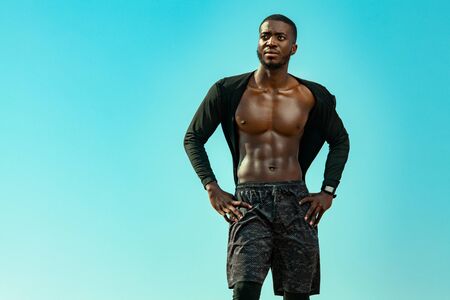 Young sportsmen man, fit athlete are standing on the sky background. Healthy lifestyle, sport...