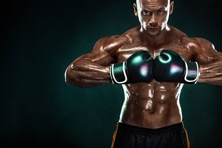 Sportsman, man boxer fighting in gloves on black background. Fitness and boxing concept. Individual sports recreation.の写真素材