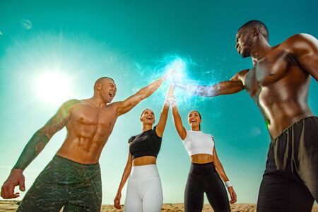 Group of sportsmens women and men, fit athletes runners after training on sky background. Healthy lifestyle and sport. Friends in black and white sportswear on workout exercise. Fitness concept.の写真素材