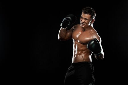 Boxer, man fighting or posing in gloves on black background. Fitness and boxing concept. Individual sports recreation.の写真素材