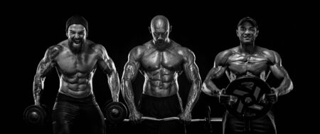 Three strong and fit men bodybuilders. Sporty muscular guys with barbell and dumbbells. Sport and fitness motivation. Individual sports recreation.の写真素材
