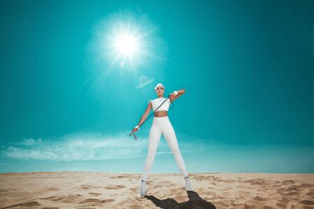 Sporty and fit woman athlete doing training with jump rope on the sky background. The concept of a healthy lifestyle and sport. Individual sports recreation.の写真素材