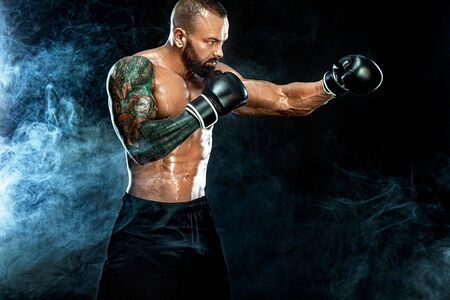 Fitness and boxing concept. Boxer, man fighting or posing in gloves on black background. Individual...