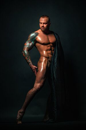 Muscular young sexy cute man bodybuilder isolated on black background.の写真素材