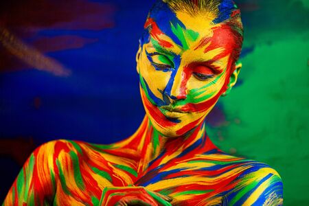 Art fashion makeup. Color face of woman for inspiration. Abstract portrait of the bright beautiful girl with colorful make-up and body art.の写真素材