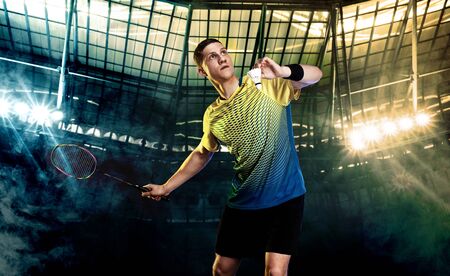 Badminton player in sportswear with racket and shuttlecock on stadium.の写真素材