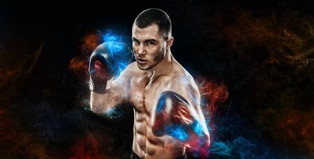Energy and power boxing concept. Sportsman muay thai boxer fighting in gloves Isolated on black background.の写真素材