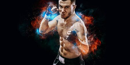Energy and power boxing concept. Sportsman muay thai boxer fighting in gloves Isolated on black background.の写真素材