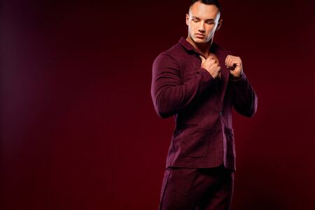 Portrait of handsome stylish man bodybuilder with naked torso in elegant suitの写真素材