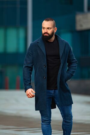 Young business man near business center looking to the future. Autumn or spring mens fashion look.の写真素材