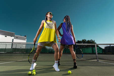Woman tennis player posing like a fitness fashion model on tennis court.の写真素材