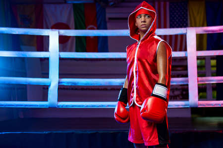 Kids sport concept. Girl sportsman muay thai boxer fighting in gloves in boxing gym.の写真素材