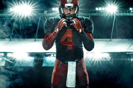 Closeup portrait of american football player, athlete sportsman in red helmet on grand arena background. Sport and motivation wallpaper.の写真素材