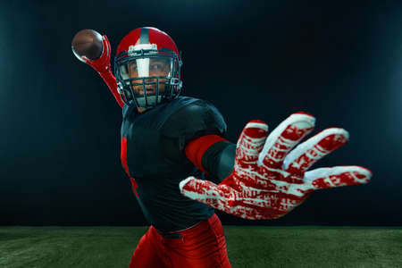 American football player, athlete sportsman in red helmet on stadium background. Sport and...