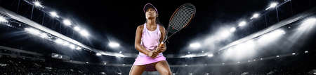 Teenager tennis player. Beautiful girl athlete with racket in pink sporswear and hat on tennis court. Fashion and sport concept. Wide photo.の写真素材