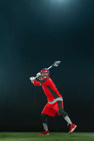 Lacrosse Player, athlete sportsman in red helmet on dark background. Sport and motivation wallpaper.の写真素材
