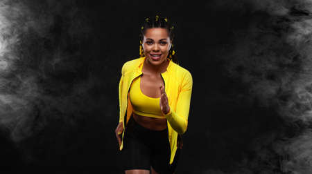 Sprinter run. Strong athletic woman running on black background wearing in the sportswear. Fitness...