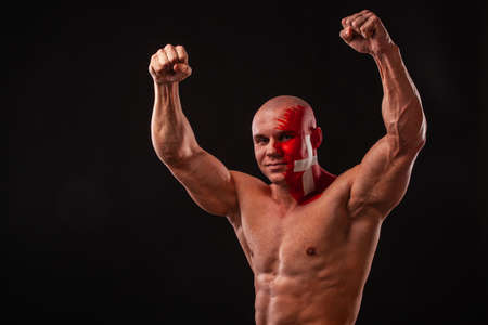 Switzerland fan. Soccer or football athlete with flag bodyart on face. Sport concept with copyspace.