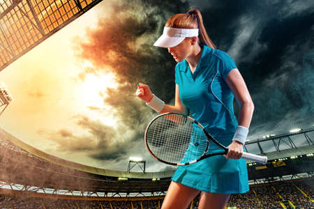 Tennis player with racket. Woman athlete celebrating victory on grand arena background after good play.の写真素材