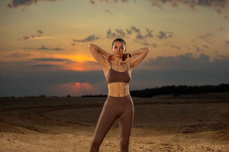 Gym and fitness concept. Muscular young sports woman doing workout outdoors.