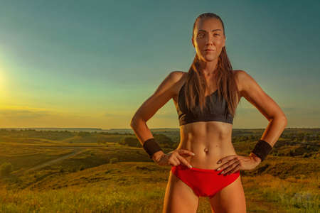Gym and fitness concept. Muscular young sports woman doing workout outdoors.