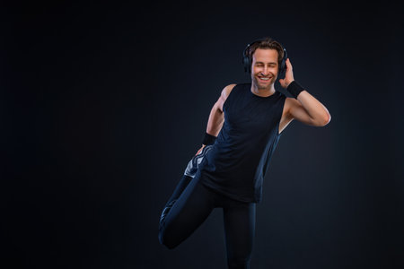 Runner concept. Sprinter run. Strong athletic man preparing for running on black background wearing in the sportswear. Fitness and sport motivation.の写真素材