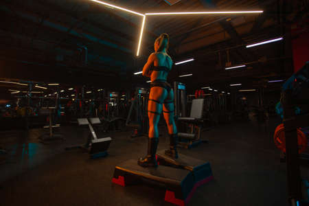 Sporty fit woman, athlete with dumbbells make fitness exercises at the gym.の写真素材