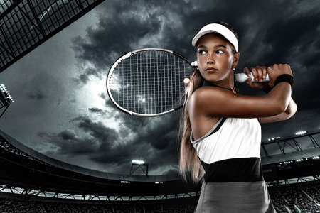 Tennis player. Beautiful girl teenager and athlete with racket in pink sporswear and hat on tennis court. Fashion and sport concept.の写真素材