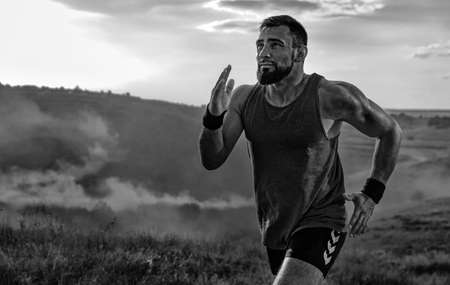 Runner concept. Athletic man running trail on sunset wearing in the sportswear. Fitness and sport...