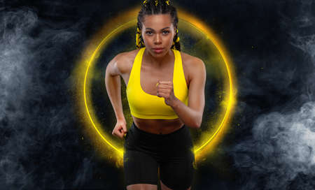 Sprinter run. Strong athletic woman running on black background wearing in the sportswear. Fitness...
