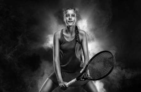 Tennis player. Beautiful girl teenager and athlete with racket in sporswear and hat on tennis court. Sport concept.の写真素材