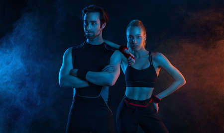 Sprinter run. Strong athletic woman and man running on black background wearing in the sportswear. Fitness and sport motivation. Runner concept.の写真素材