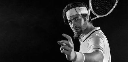 Tennis player with racket in black t-shirt. Man athlete playing isolated on black background.の写真素材